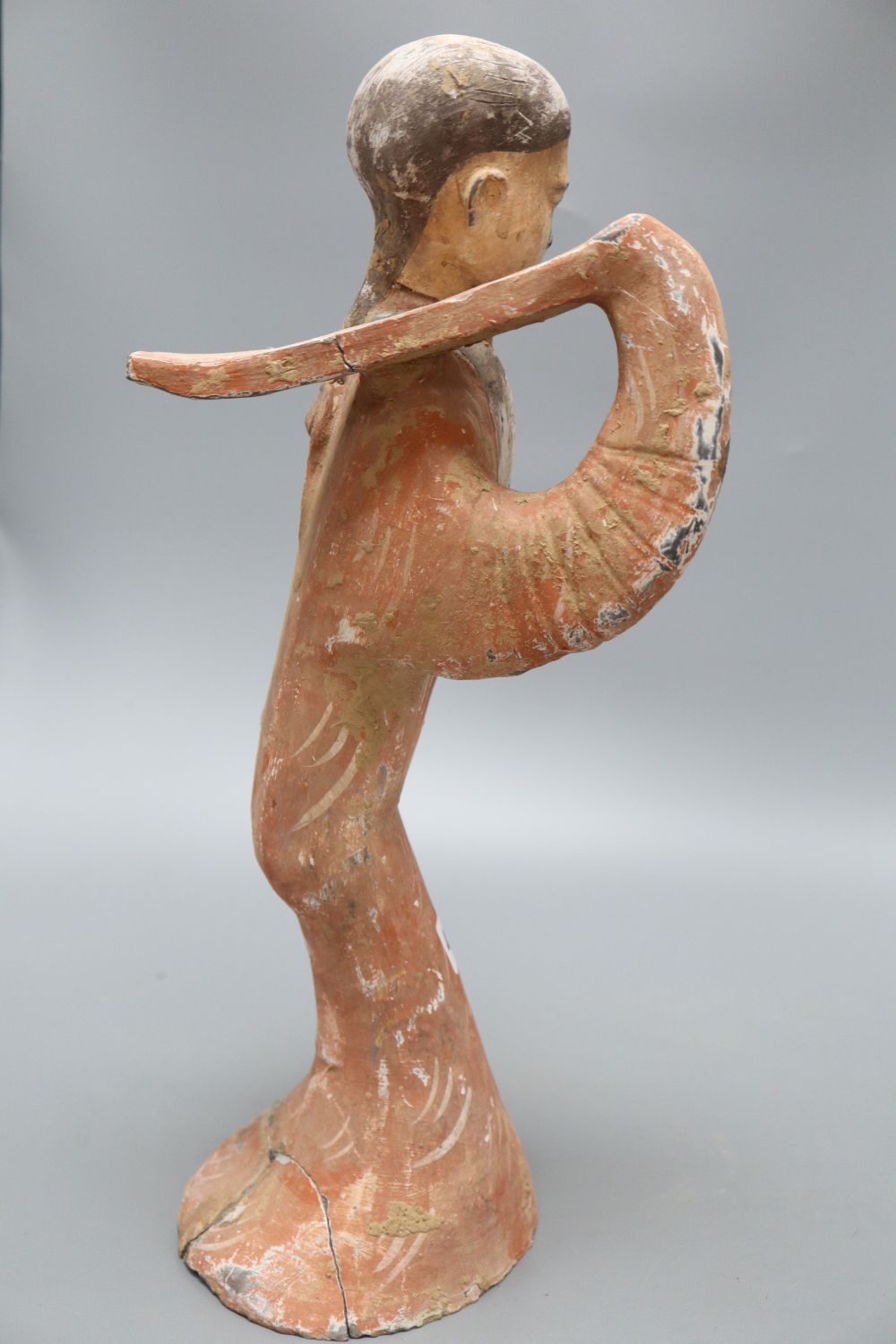 A Chinese painted pottery figure of a dancer, Han dynasty or later, height 45cm